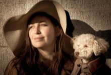 grayscale photo of woman with long coated dog