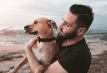 man holding a brown dog
