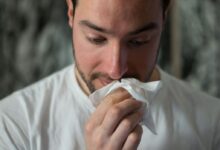 man wiping mouse with tissue paper