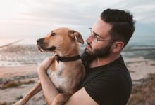 man holding a brown dog