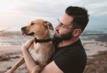 man holding a brown dog