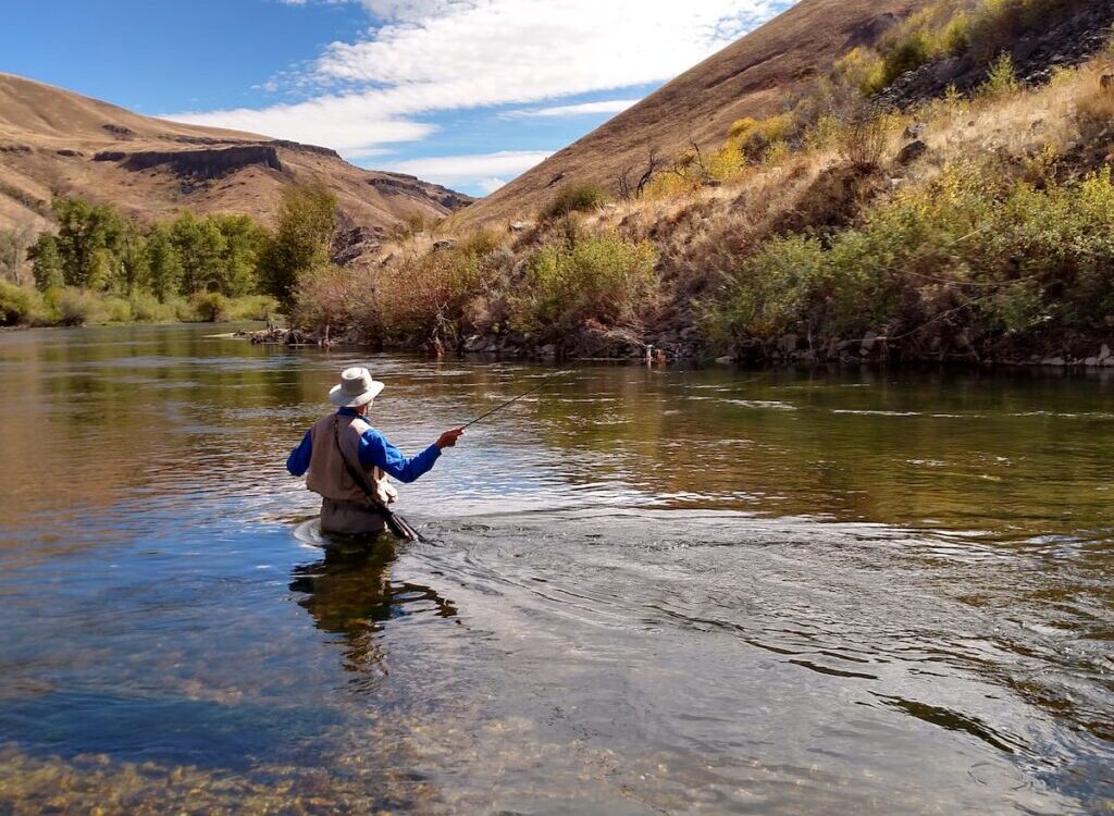 man wearing brown hat fishing on water