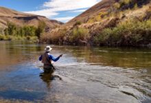 man wearing brown hat fishing on water