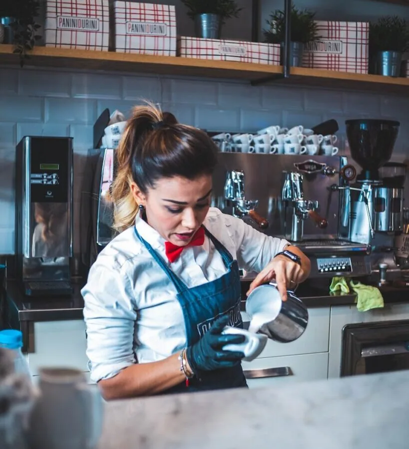 woman pouring liquid on mug