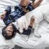woman lying on bed with white Siberian husky