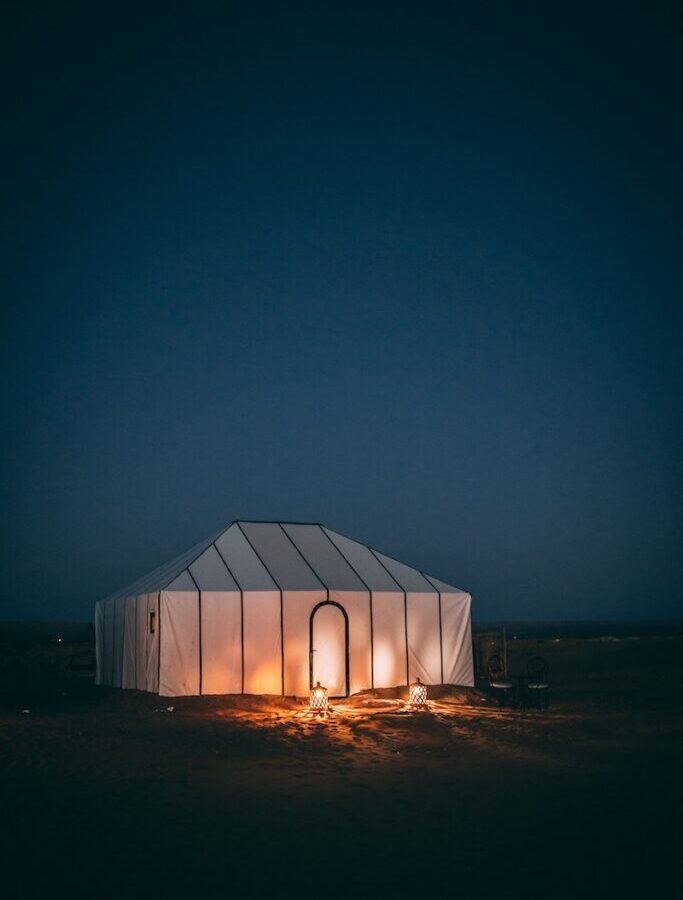 White Tent on Brown Sand during Night Time