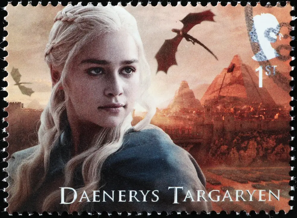 - NeposlušnéTlapky Poštovní známka s Daenerys Targaryen, za ní v pozadí krajina a draci