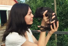 Žena drží malé prasátko