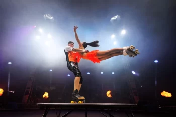 Žena a muž performují na kolečkových bruslích