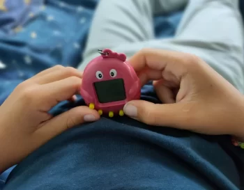 Chlapec drží v rulou růžové Tamagotchi