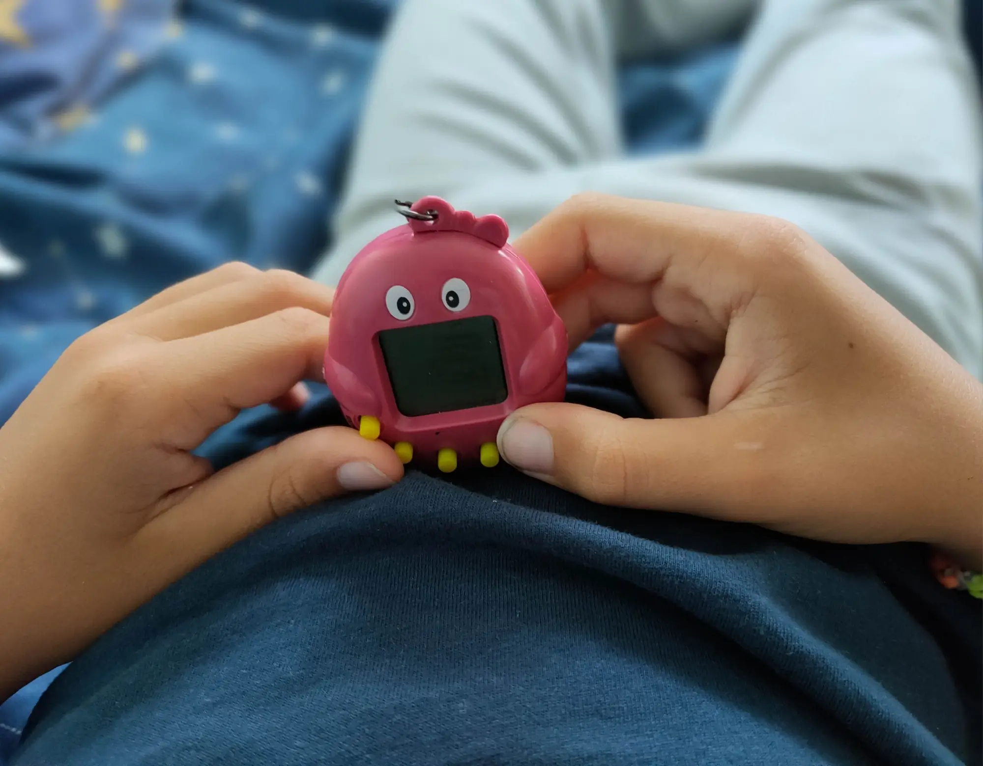 Chlapec drží v rulou růžové Tamagotchi