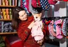 Žena vybírá v obchodě obleček pro psíka