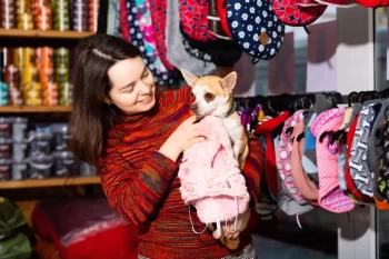 Žena vybírá v obchodě obleček pro psíka